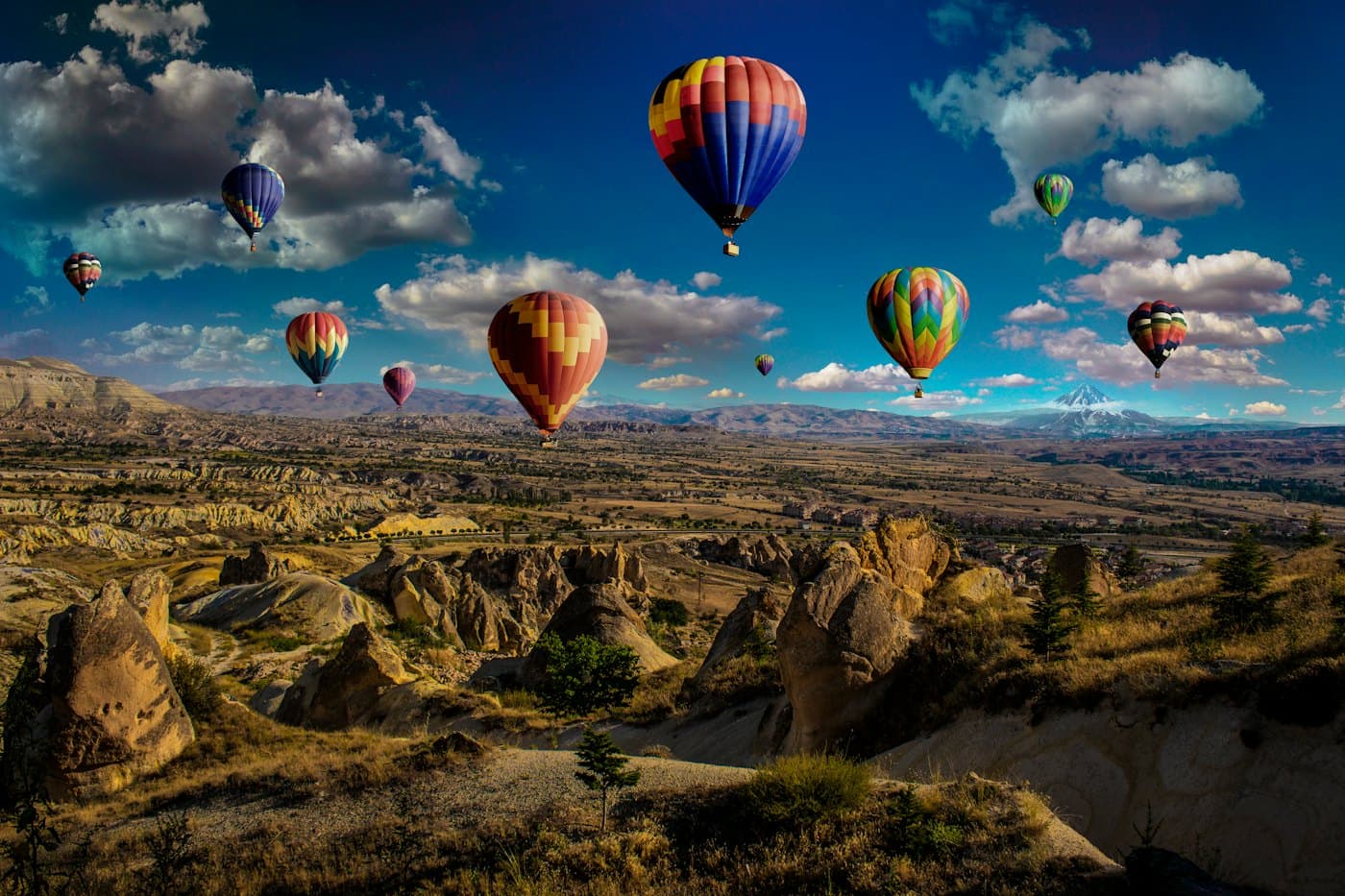 Hot air balloons drifting over a rocky valley
