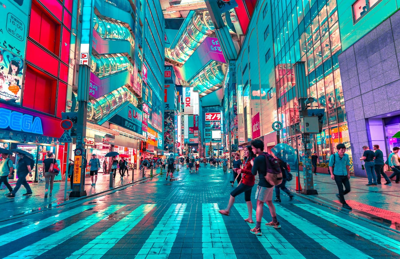 People crossing a bright, sign-covered street in Tokyo